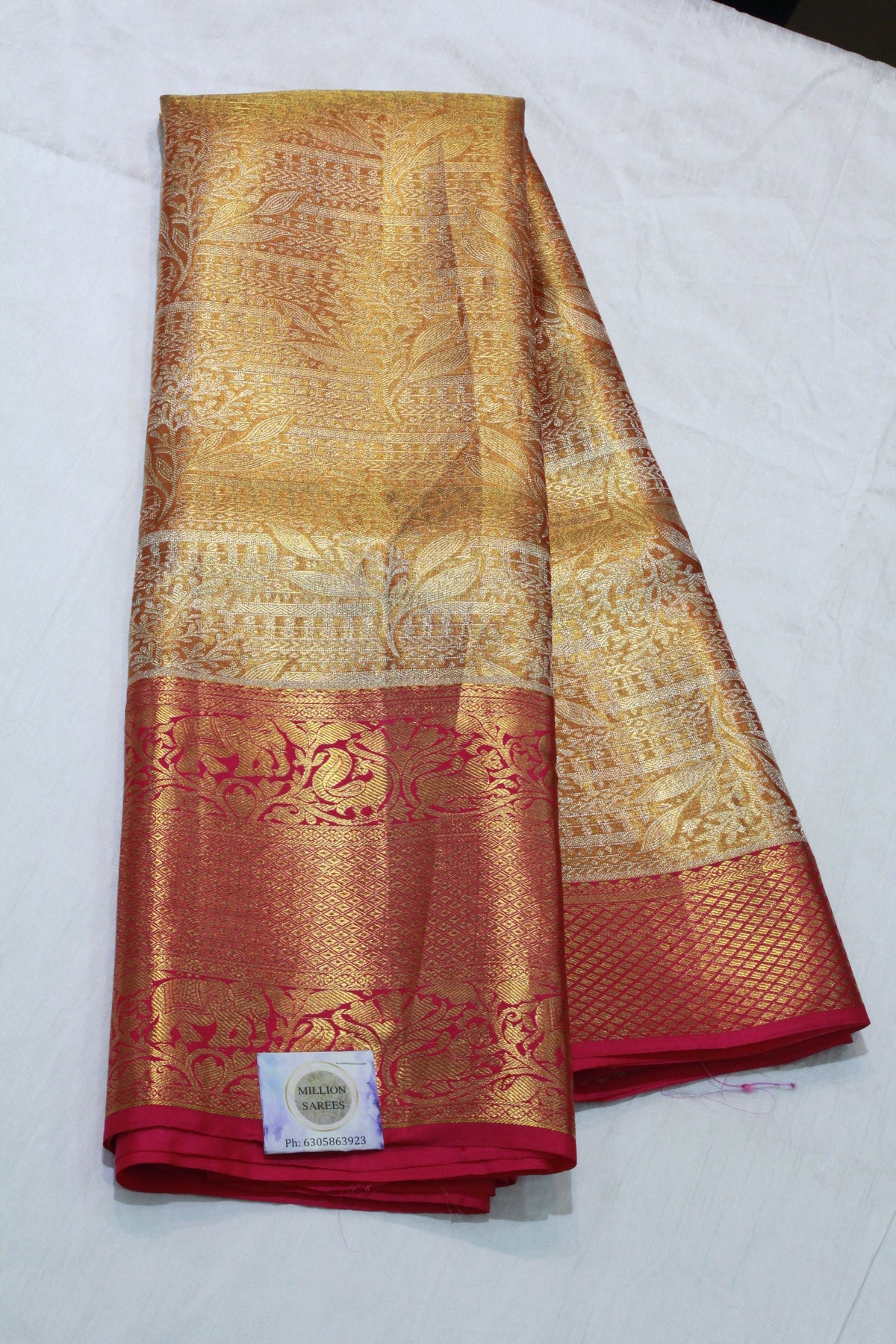 Red and gold saree with intricate patterns on a white background